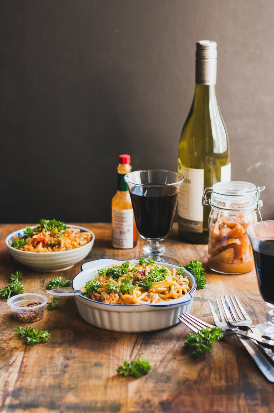 Due ciotole di pasta con vino e verdure sottaceto su un tavolo.